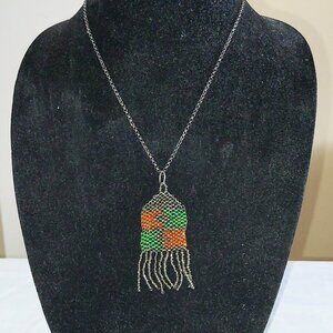 20" chain necklace with beaded 2 1/2" orange and green pendant with fringe.